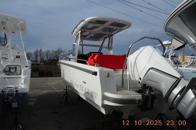 Slide: The Image of 2025 Nimbus Tender 8 boat with outboard motor, docked outdoors under a cloudy sky. - 16
