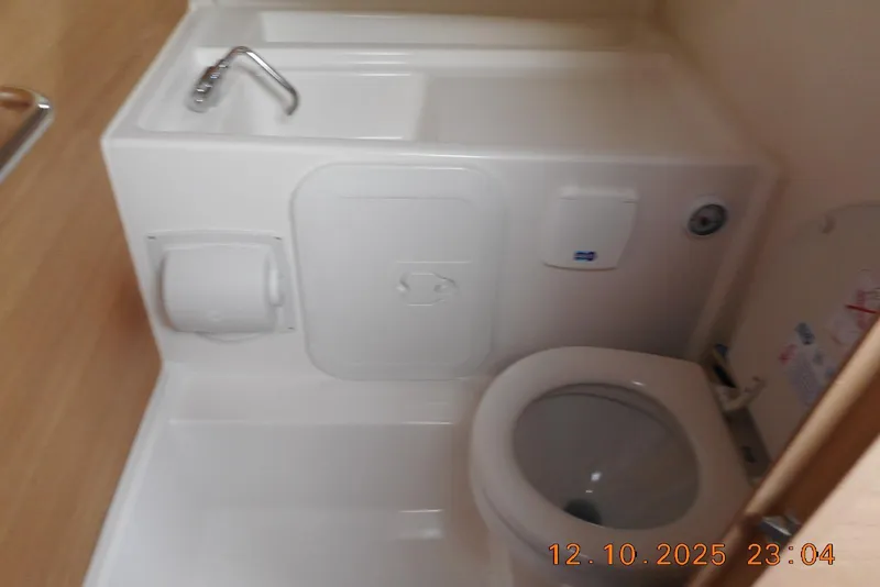 Slide: The Image of Compact bathroom in 2025 Nimbus Tender 8 boat, featuring a toilet and sink. - 19