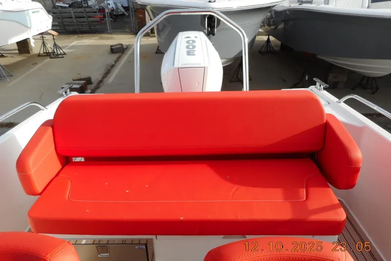Slide: The Image of Red seating on 2025 Nimbus Tender 8 boat, docked with visible engine. - 22