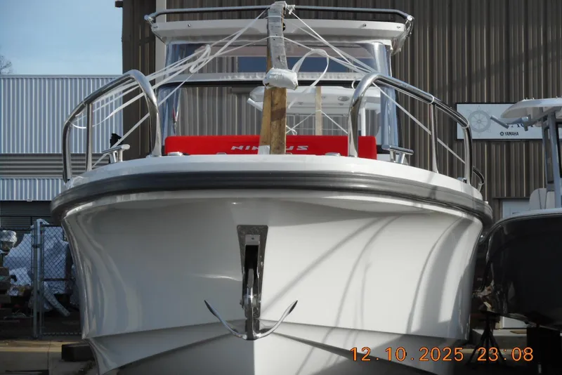 Slide: The Image of 2025 Nimbus Tender 8 boat docked, front view with metal railings and anchor. - 4