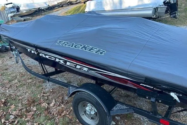 Slide: The Image of 2020 Tracker Pro Team 175 TF boat covered on trailer, parked outdoors. - 4