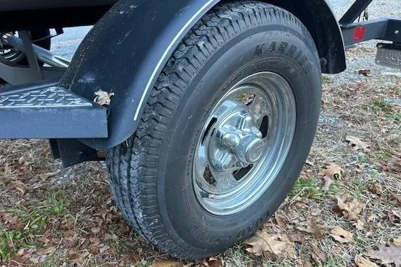 Slide: The Image of 2020 Tracker Pro Team 175 TF trailer tire on grassy ground with fallen leaves. - 5