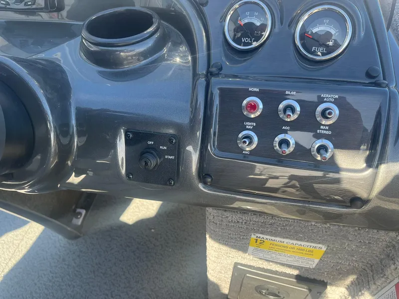 Slide: The Image of 2025 Lowe Deck SD224 boat dashboard with gauges and control switches. - 21