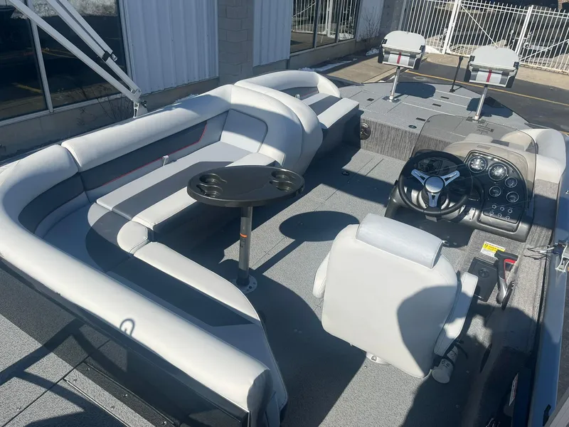 Slide: The Image of 2025 Lowe Deck SD224 boat interior with seating, steering console, and table. - 4