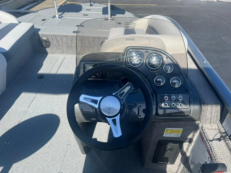 Slide: The Image of 2025 Lowe Deck SD224 boat dashboard with steering wheel and control gauges. - 7