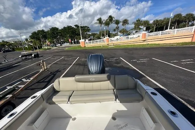 Slide: The Image of 2022 Key West 239 FS boat interior with seating, parked in sunny lot. - 10
