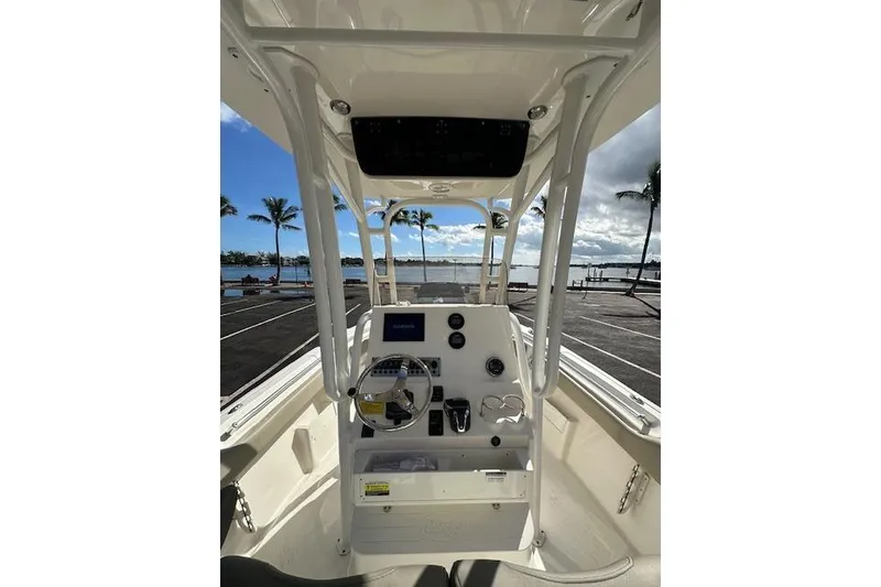 Slide: The Image of 2022 Key West 239 FS boat interior with steering console, parked near waterfront. - 5