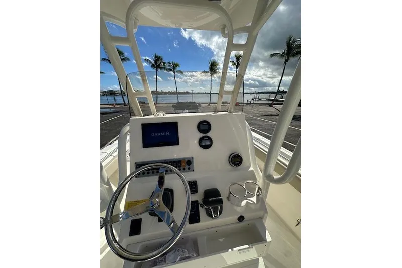 Slide: The Image of 2022 Key West 239 FS boat dashboard with Garmin display, steering wheel, and ocean view. - 6