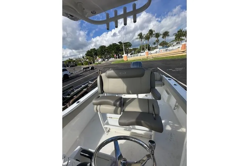 Slide: The Image of 2022 Key West 239 FS boat interior with cushioned seating and steering wheel. - 9