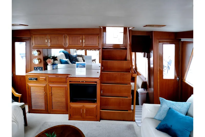 Slide: The Image of 1985 Ocean Alexander Custom Aft Deck Motoryacht interior with wooden cabinetry and cozy seating. - 11