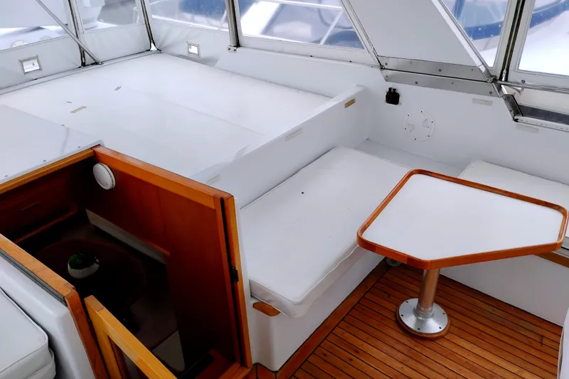 Slide: The Image of 1985 Ocean Alexander Custom Aft Deck Motoryacht with white seating and wooden table. - 13