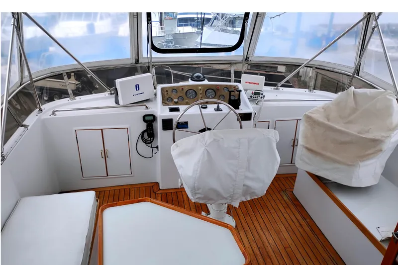 Slide: The Image of 1985 Ocean Alexander Custom Aft Deck Motoryacht helm with wooden flooring and covered seating. - 15