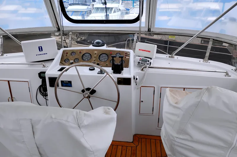Slide: The Image of 1985 Ocean Alexander Custom Aft Deck Motoryacht helm with navigation equipment and wooden flooring. - 17