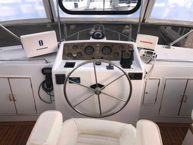 Slide: The Image of 1985 Ocean Alexander Custom Aft Deck Motoryacht helm with steering wheel and navigation instruments. - 19