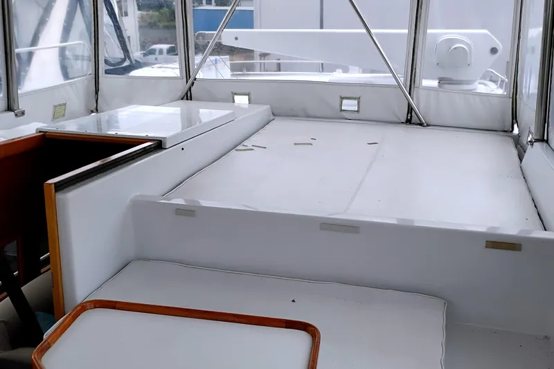 Slide: The Image of 1985 Ocean Alexander Custom Aft Deck Motoryacht interior with white seating and wooden accents. - 21