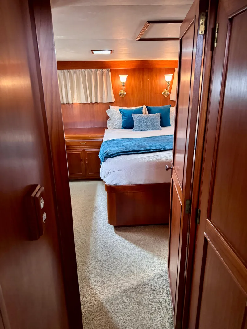 Slide: The Image of Cozy bedroom in 1985 Ocean Alexander Custom Aft Deck Motoryacht with wood paneling and blue accents. - 26