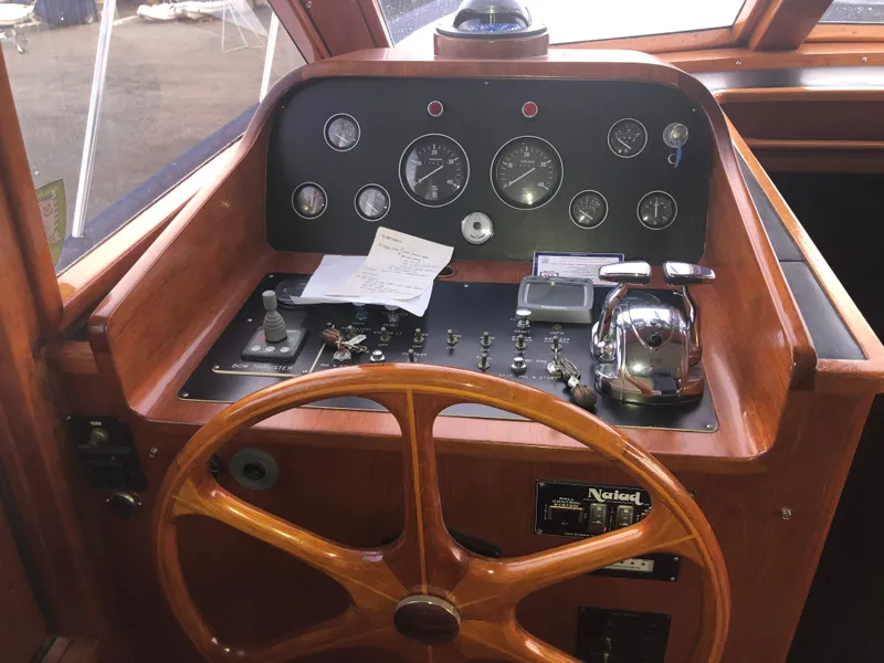 Slide: The Image of 1985 Ocean Alexander Custom Aft Deck Motoryacht helm with wooden wheel and control panel. - 39
