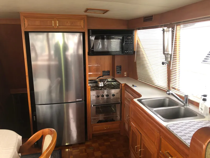 Slide: The Image of 1985 Ocean Alexander Custom Aft Deck Motoryacht kitchen with stainless steel appliances and wooden cabinetry. - 41