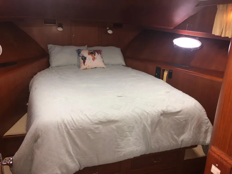 Slide: The Image of Cozy bedroom in 1985 Ocean Alexander Custom Aft Deck Motoryacht with wood paneling and soft lighting. - 47