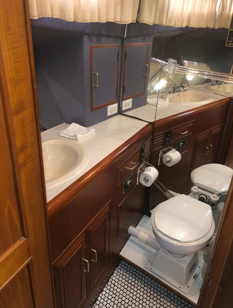 Slide: The Image of 1985 Ocean Alexander Custom Aft Deck Motoryacht bathroom with dual sinks and wooden cabinetry. - 48