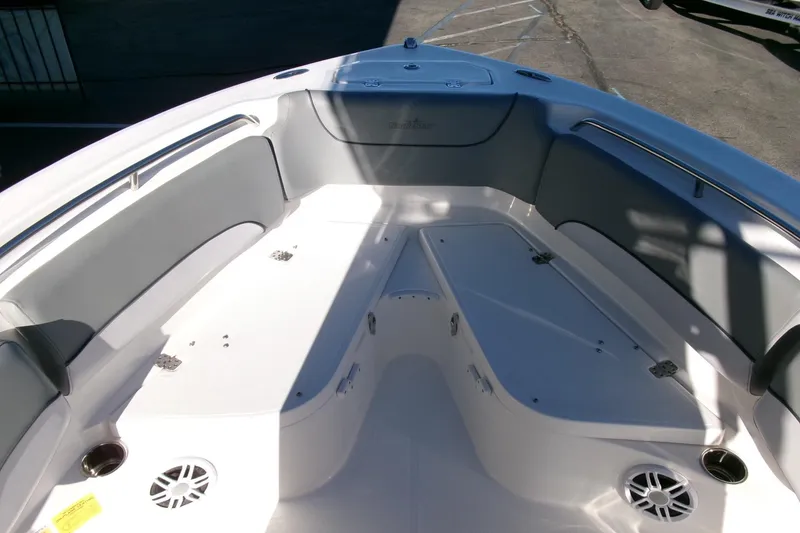 Slide: The Image of 2023 NauticStar 2102 Legacy boat interior with cushioned seating and storage compartments. - 10