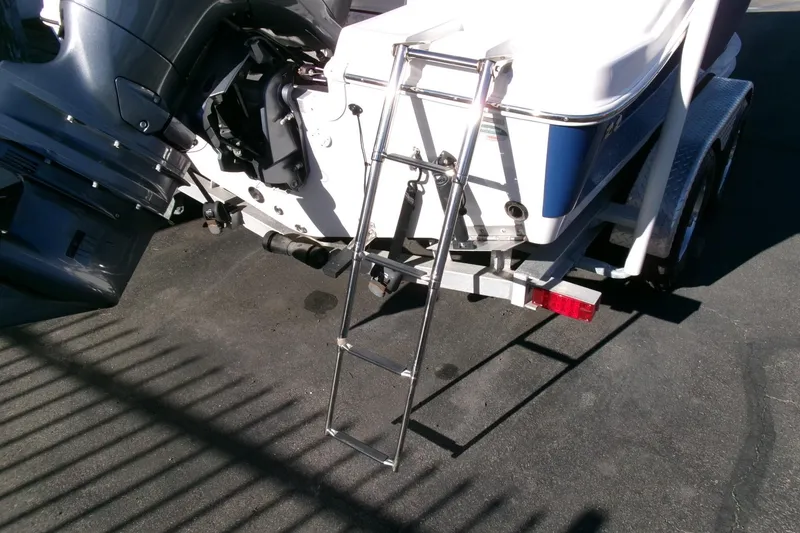 Slide: The Image of 2023 NauticStar 2102 Legacy boat with ladder and outboard motor on trailer. - 25