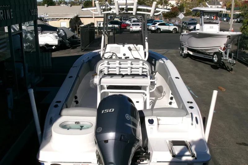 Slide: The Image of 2023 NauticStar 2102 Legacy boat with Yamaha 150 engine, parked outdoors. - 28