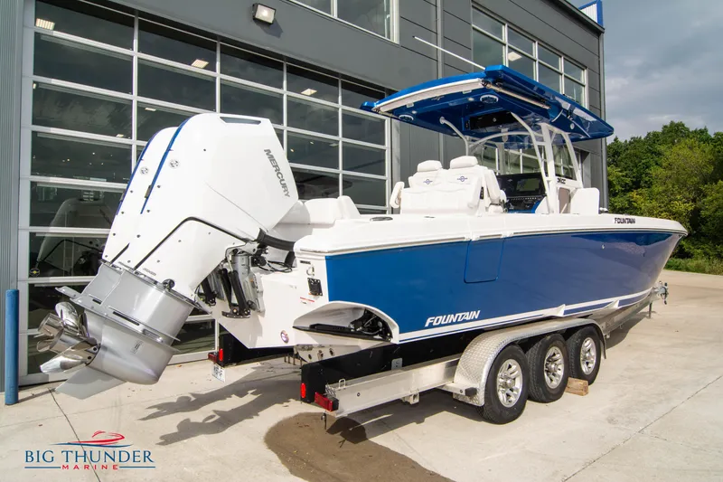 Slide: The Image of 2023 Fountain 34 Center Console boat with Mercury engines, parked on a trailer outside a showroom. - 5