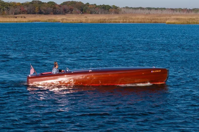 The Image of Custom 1998 30 Gentleman's Racer boat cruising on a serene lake. - 0