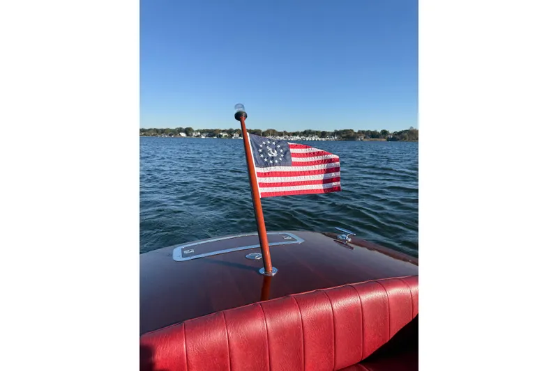Slide: The Image of Custom 30 Gentleman's Racer boat with American flag on lake, 1998 model. - 19