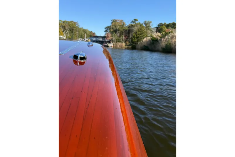 Slide: The Image of Custom 30 Gentleman's Racer boat, 1998, with polished wooden deck on a serene river. - 20