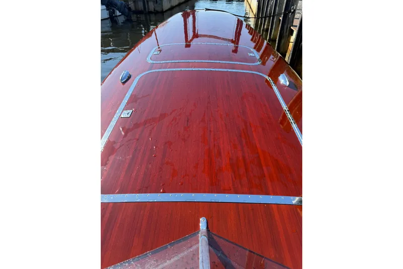 Slide: The Image of Custom 1998 30 Gentleman's Racer with polished wooden deck, docked by the water. - 22