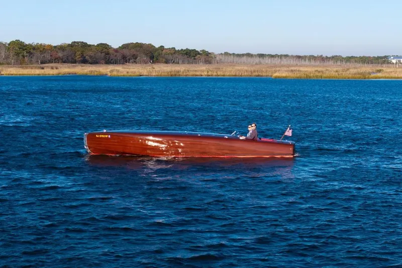 Slide: The Image of Custom 1998 30 Gentleman's Racer boat cruising on a serene lake with scenic background. - 4