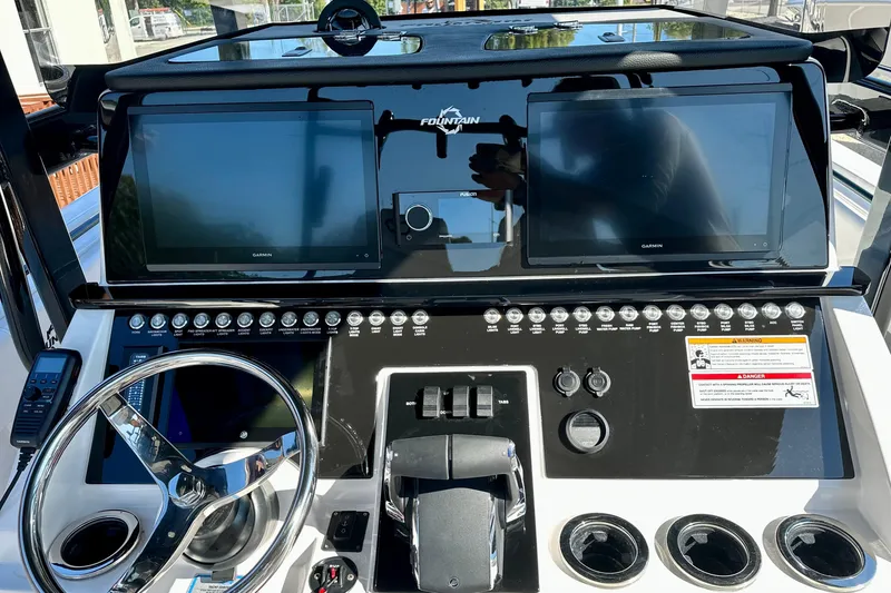 Slide: The Image of 2024 Fountain 34 Tournament Edition boat dashboard with dual Garmin displays and controls. - 12