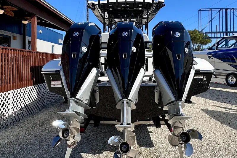 Slide: The Image of 2024 Fountain 34 Tournament Edition boat with triple outboard engines, docked outdoors. - 4
