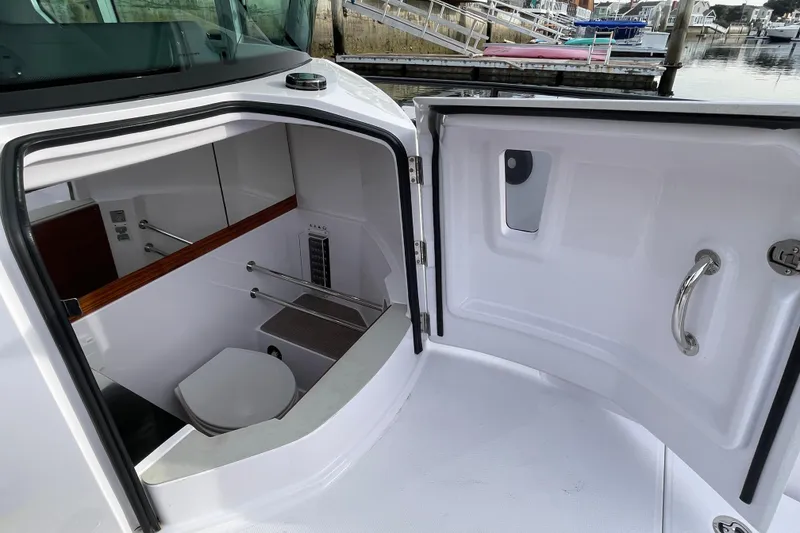 Slide: The Image of Interior of 2023 Axopar 28 Cabin featuring a toilet. - 15