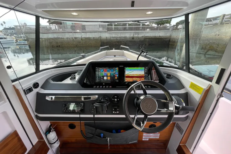 Slide: The Image of 2023 Axopar 28 Aft Cabin with Brabus Trim helm featuring advanced navigation displays. - 18