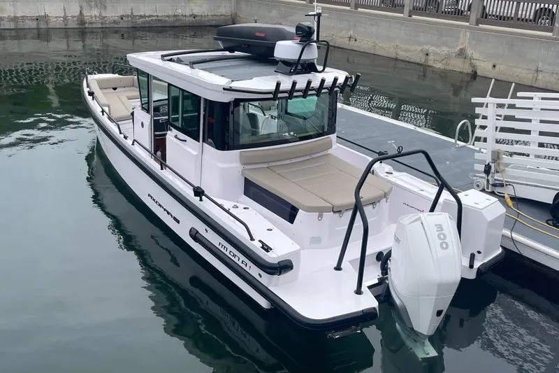 Slide: The Image of 2023 Axopar 28 Aft Cabin with Brabus Trim, docked with fishing rods. - 2