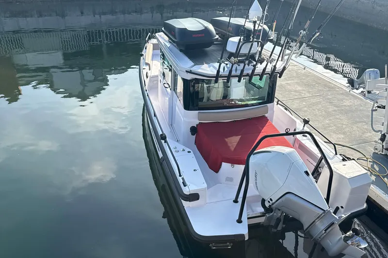 Slide: The Image of 2023 Axopar 28 Aft Cabin with Brabus Trim on water near rocky shore. - 3