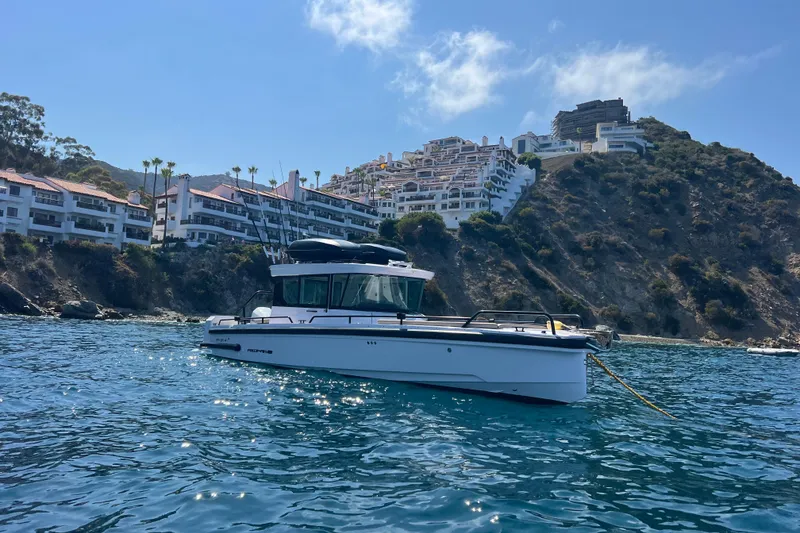 Slide: The Image of 2023 Axopar 28 Cabin with red cover on water. - 6