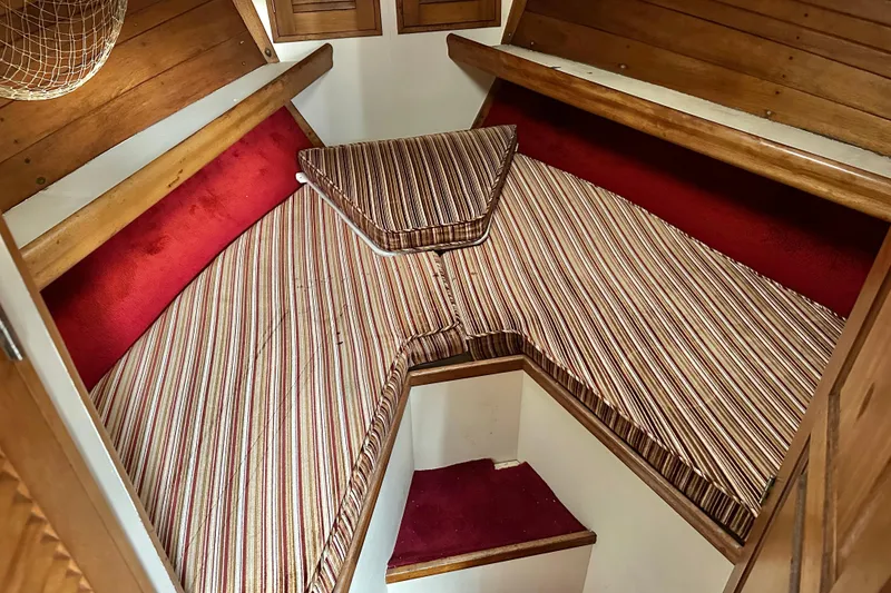 Slide: The Image of Cozy cabin interior of 1970 CAL 46 Cruiser with striped cushions and wooden accents. - 13