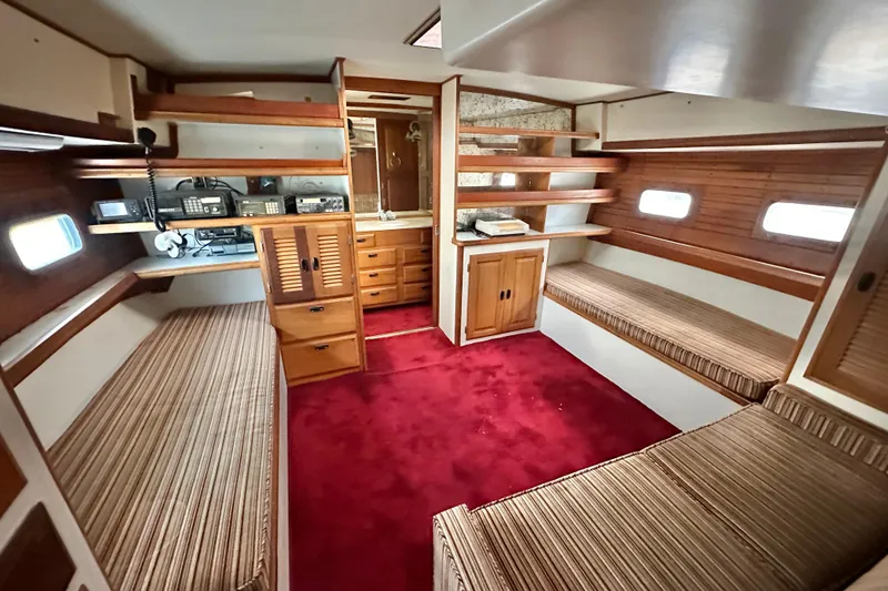Slide: The Image of Interior of 1970 CAL 46 Cruiser with red carpet, wooden shelves, and striped seating. - 14