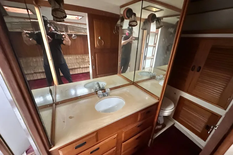 Slide: The Image of 1970 CAL 46 Cruiser bathroom with wooden cabinets, mirrored vanity, and sink. - 18