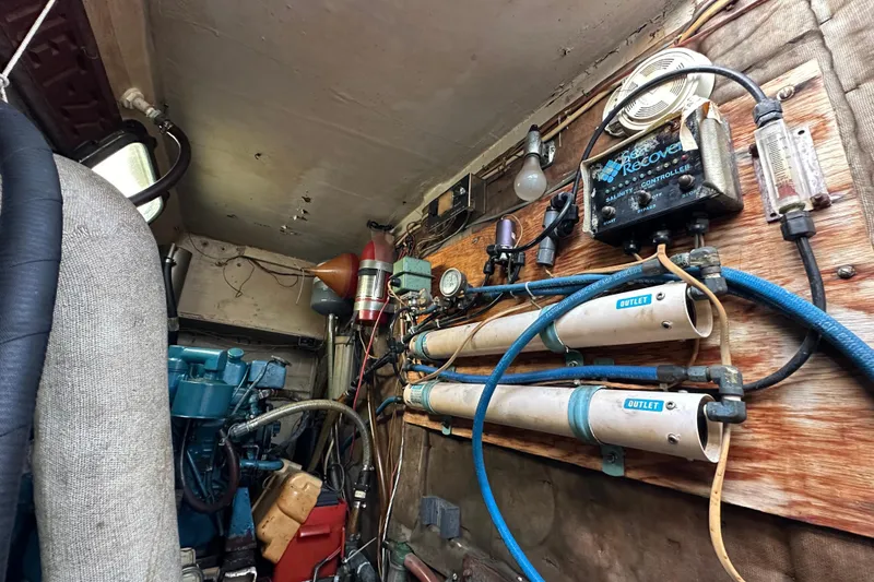 Slide: The Image of Engine room of a 1970 CAL 46 Cruiser with various mechanical components and wiring. - 26