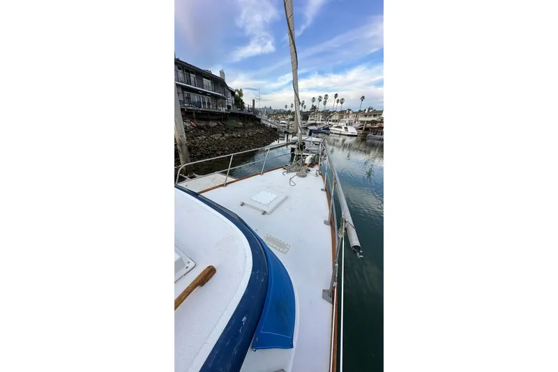Slide: The Image of 1970 CAL 46 Cruiser sailboat docked in a marina with clear skies. - 27
