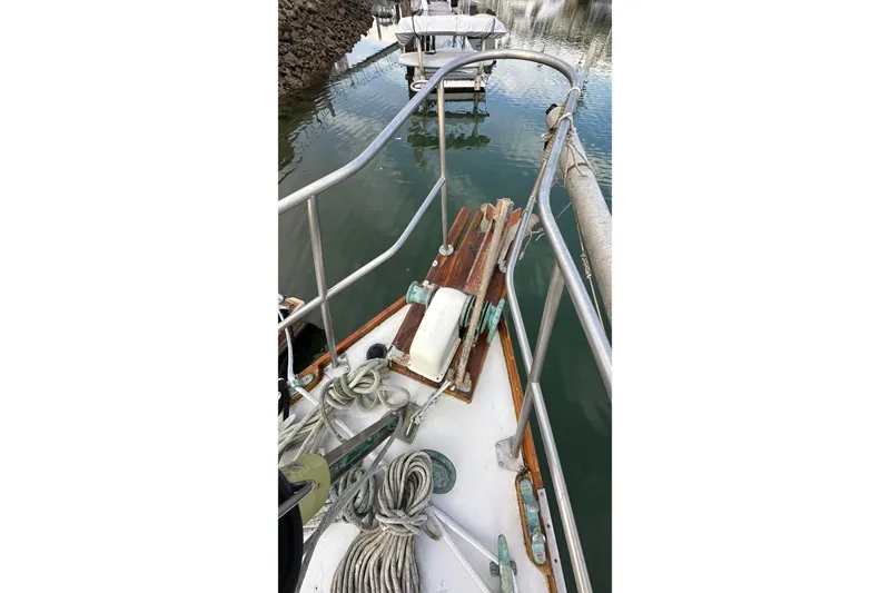 Slide: The Image of 1970 CAL 46 Cruiser sailboat deck with ropes and railing in a marina. - 28