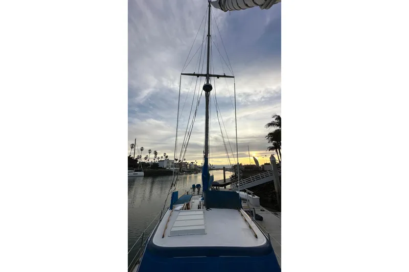 Slide: The Image of 1970 CAL 46 Cruiser sailboat docked at sunset with palm trees in the background. - 30