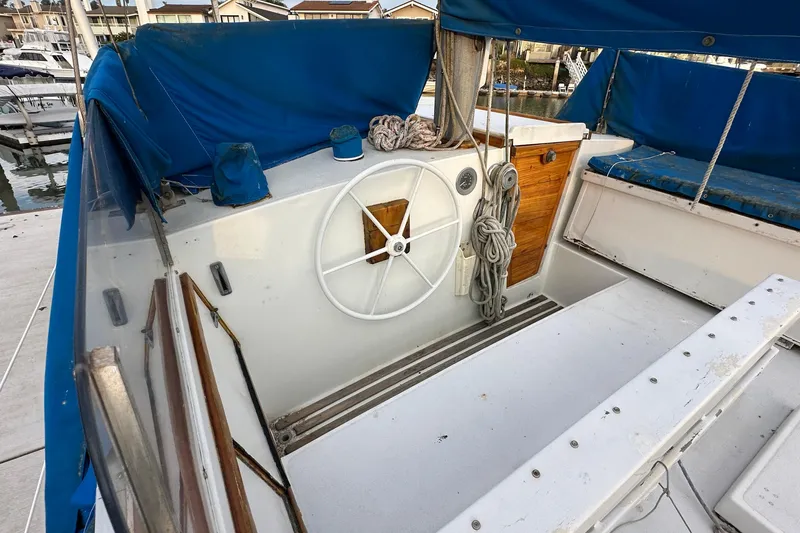 Slide: The Image of 1970 CAL 46 Cruiser sailboat cockpit with blue canopy and white steering wheel. - 33