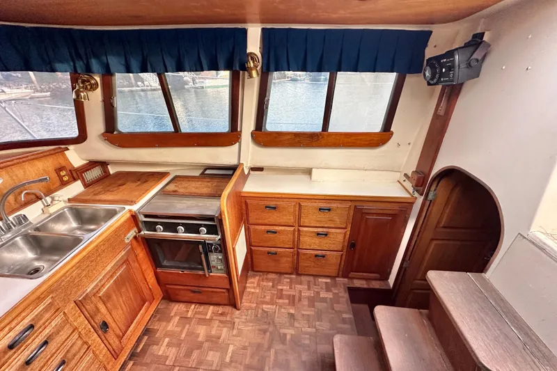 Slide: The Image of Interior of 1970 CAL 46 Cruiser with wooden cabinetry and kitchen appliances. - 7
