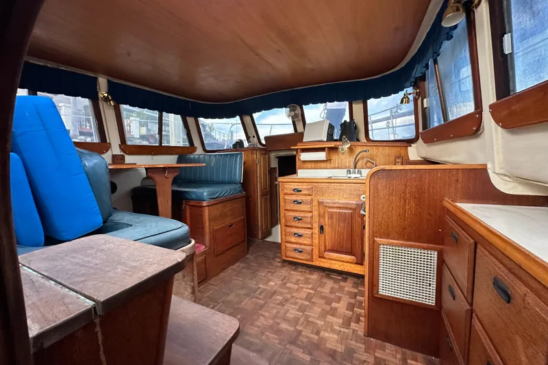 Slide: The Image of Interior of a 1970 CAL 46 Cruiser yacht with wood finish and blue seating. - 8